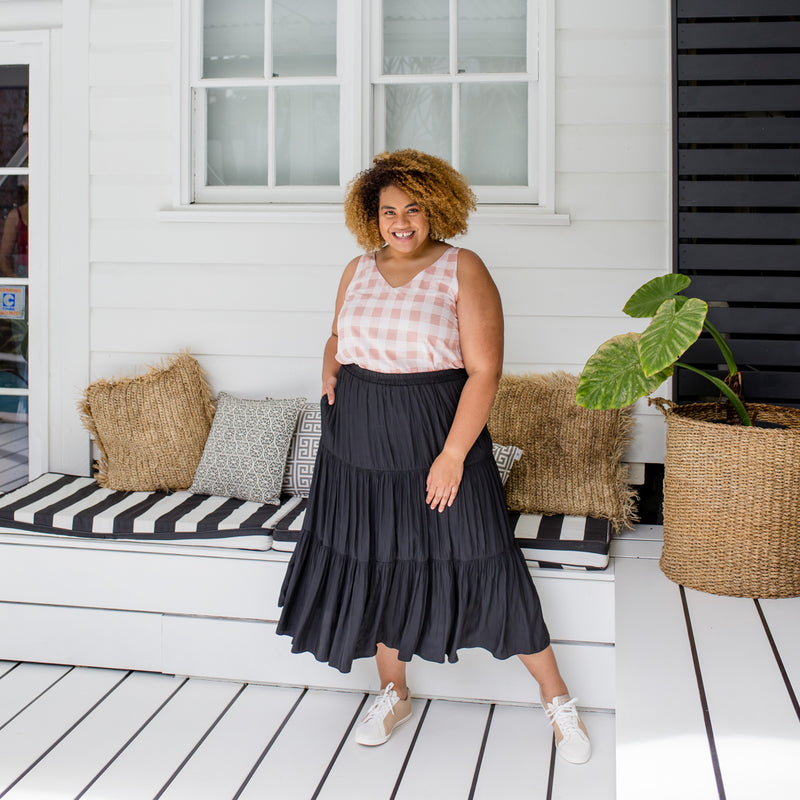 Asinate is wearing our Violet cami in peach check tucked into Sophie maxi skirt in black with white and tan sneakers