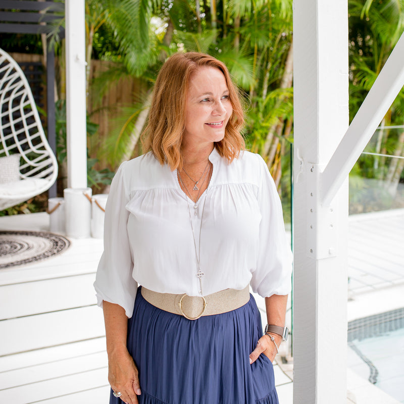 Karen is wearing our Felicity technical billow blouse in white tucked into Sophie maxi skirt in steel blue with natural colour belt.