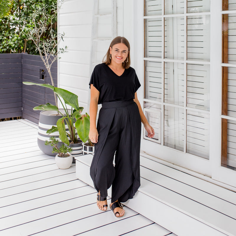 Jasmine wearing our Alexa tee tucked into our Maria technical split pant in black and black slides