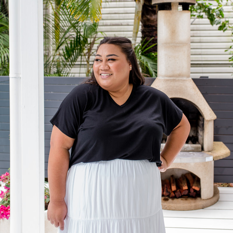 Charity is wearing our Alexa tee in black tucked into Sophie technical maxi skirt in white