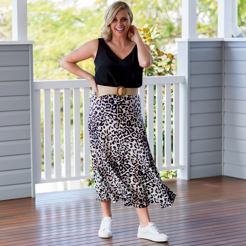 Brooke in our  Rachael technical cami - black tucked into our  Kutira midi skirt - animal print with a belt and white sneakers 